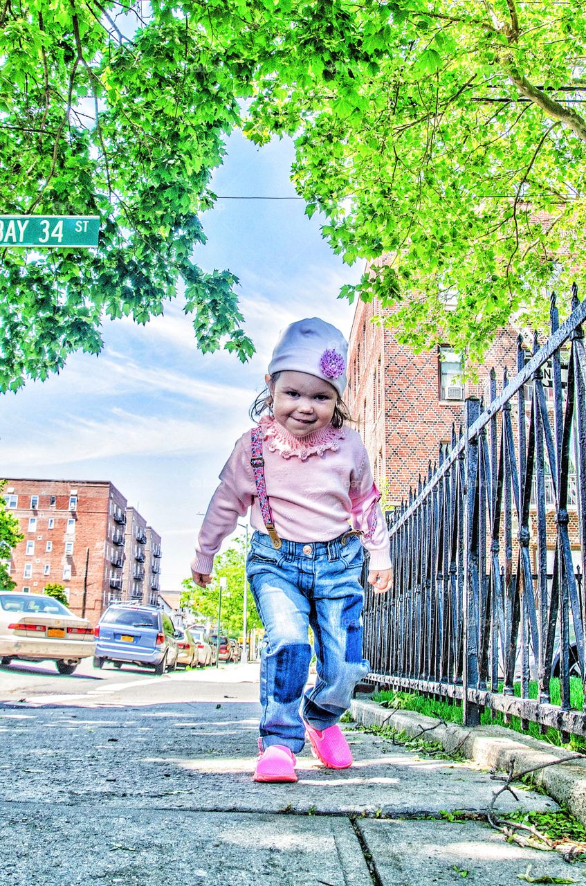 Happy girl walking on sidewalk