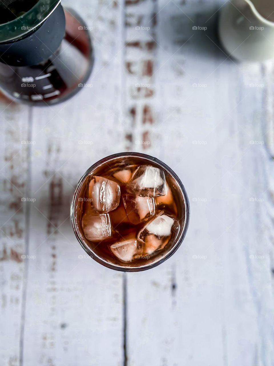 View from above a cup of iced coffee. Americano on a wooden table