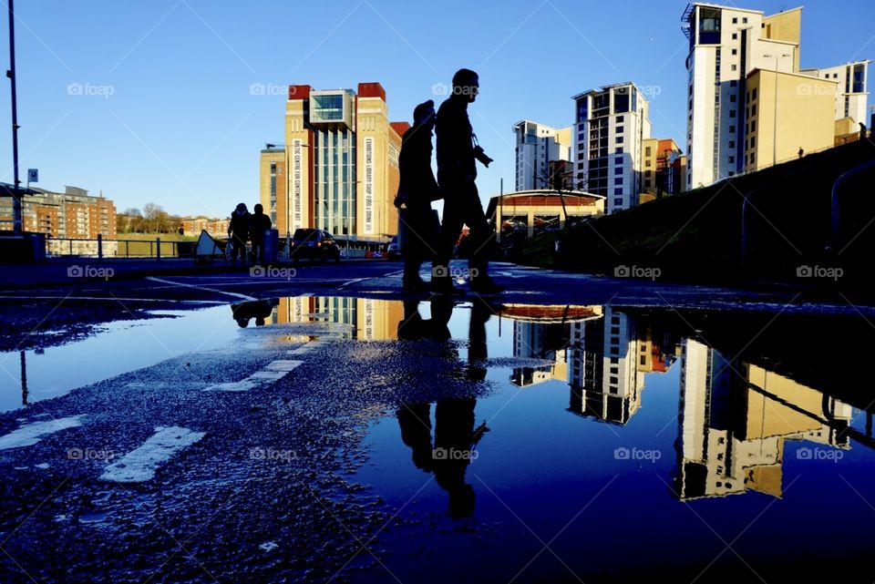 Photographers out and about in Gateshead ... their silhouettes seen clearly against the blue sky and their shadows reflected in a puddle ... I wonder what they photographed ?