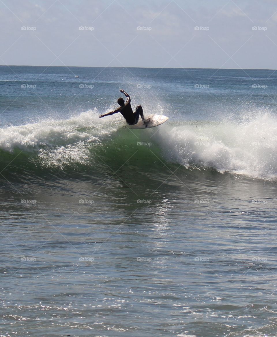 Surfer at the top of a wave at Secret Spot in Dakar, Senegal
