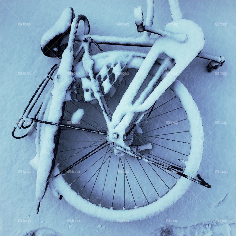 Bicycle and umbrella abandoned in the snow 