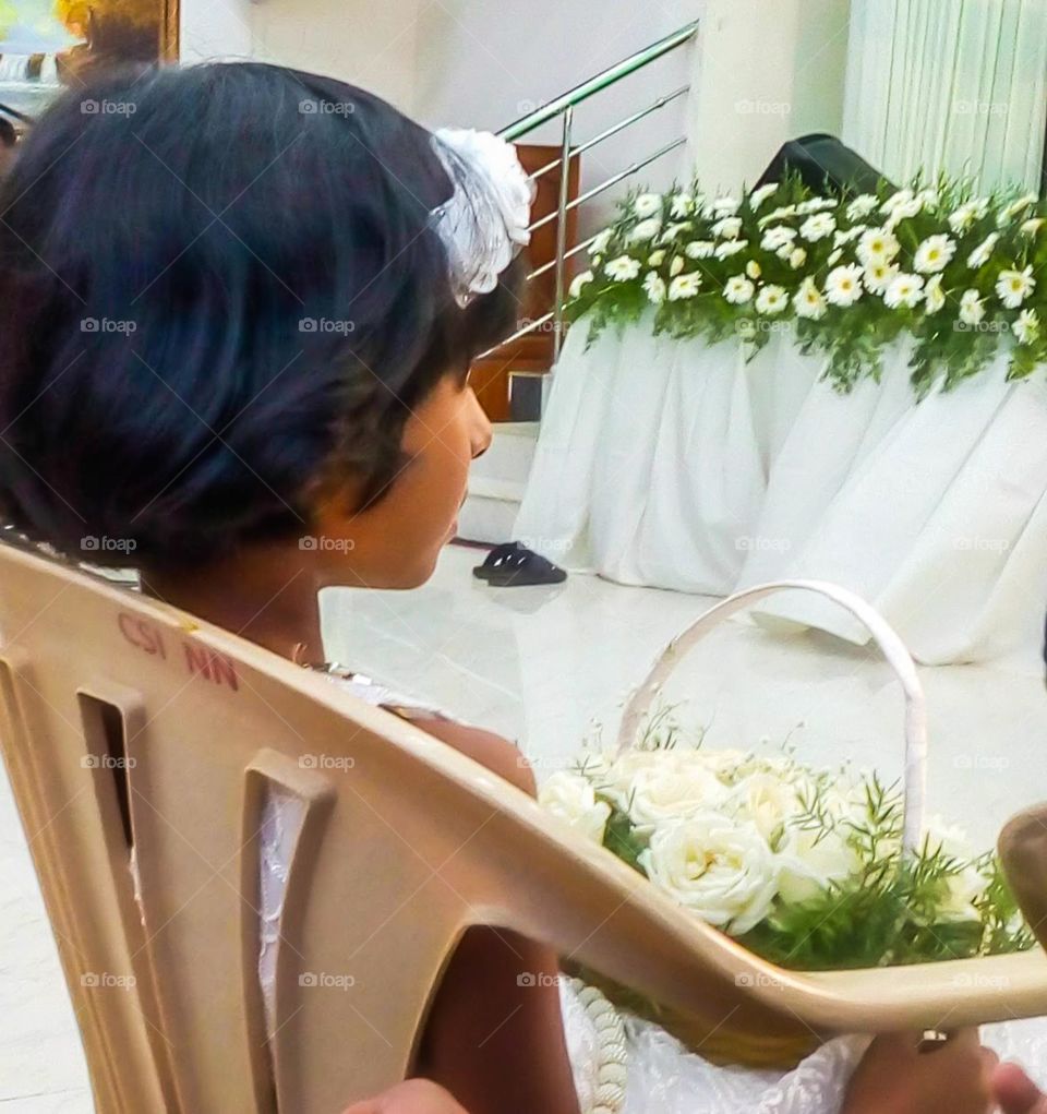 Flower girl with basket in the wedding hall