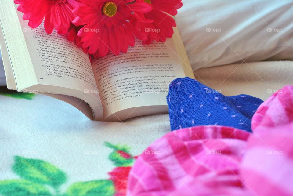 Relaxing, reading a book, in bed, pajamas and socks, lazy day, blue red white pink, flower, cozy