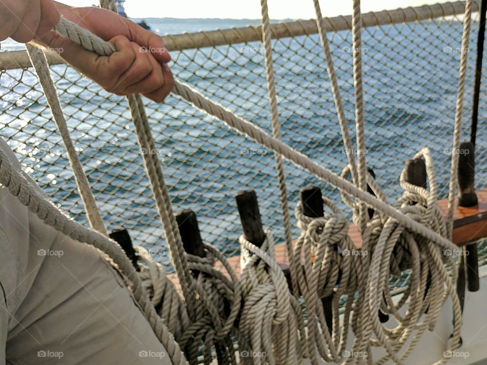 working hands on sail boat rigging ropes