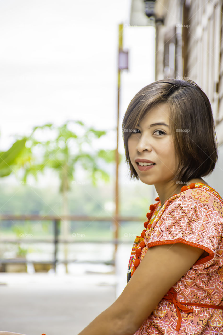 Portrait of Asean woman wearing a native of northern Thailand  background wooden wall.