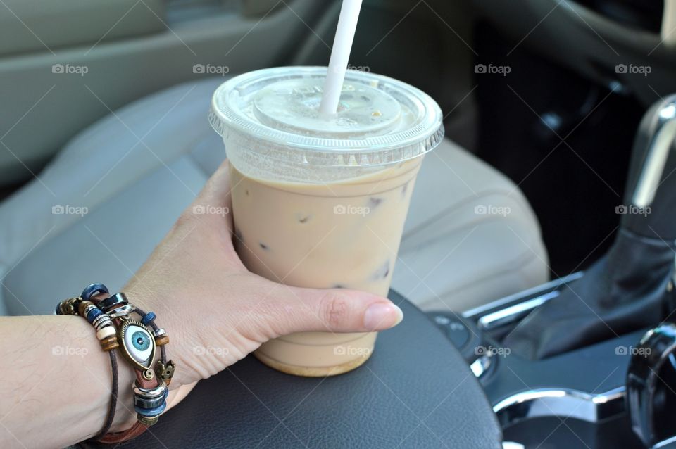 Handmade bracelet hand holding iced coffee
