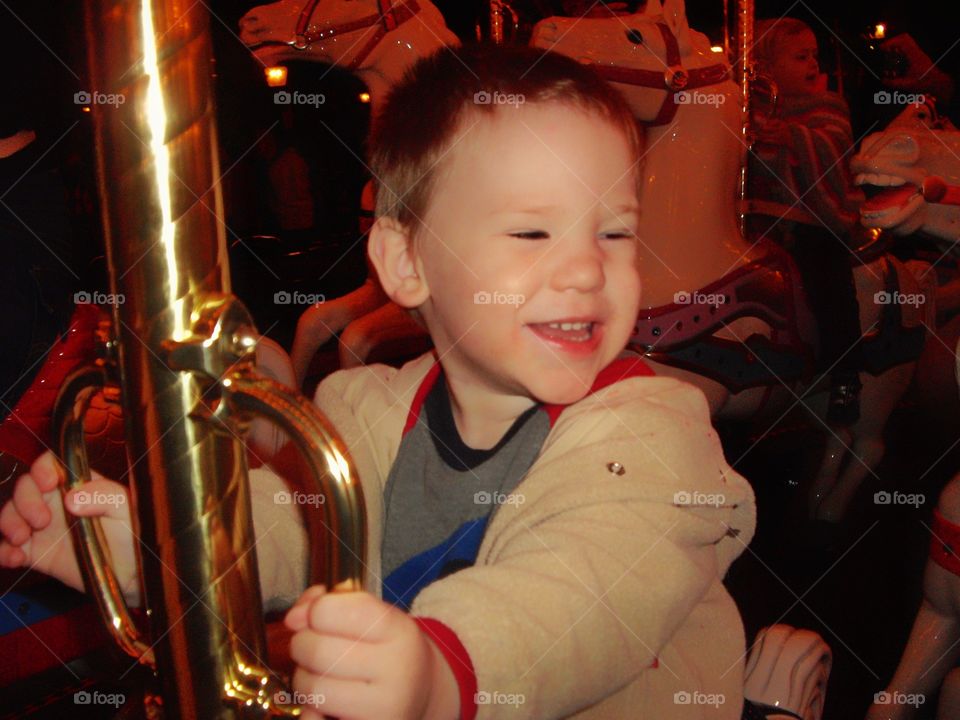 Young Boy Riding A Carousel
