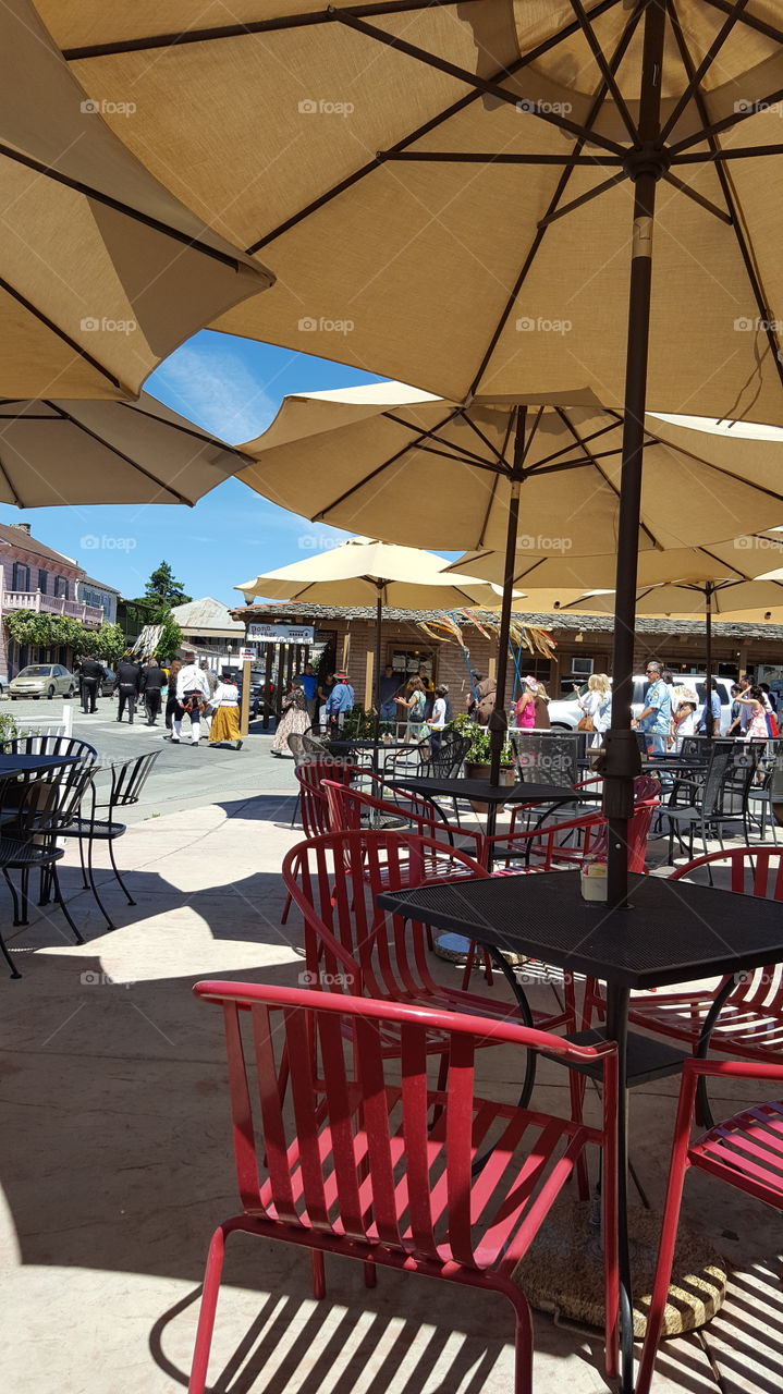 sitting enjoying a cold drink on a qarm sunny afternoon watching a procession lead by mariachis toward the mission in San Juan Bautista.