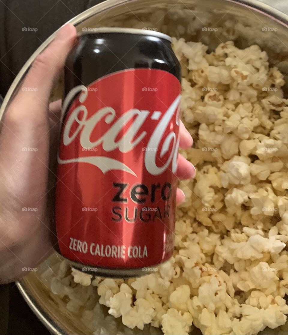 Holding a Coke Zero can and popcorn 