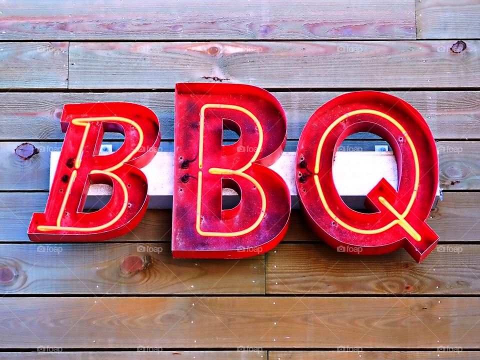 Red Color - Inviting Red metal BBQ Sign hanging on a wooden background 