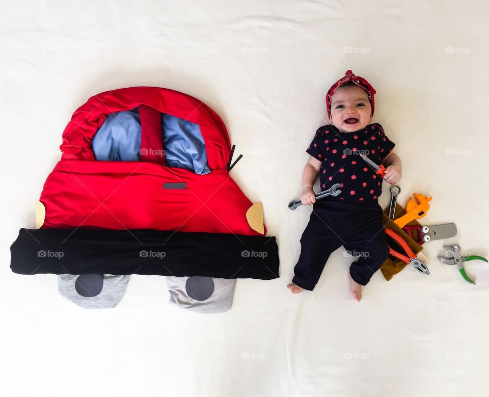 Kid lying on bed with work tools