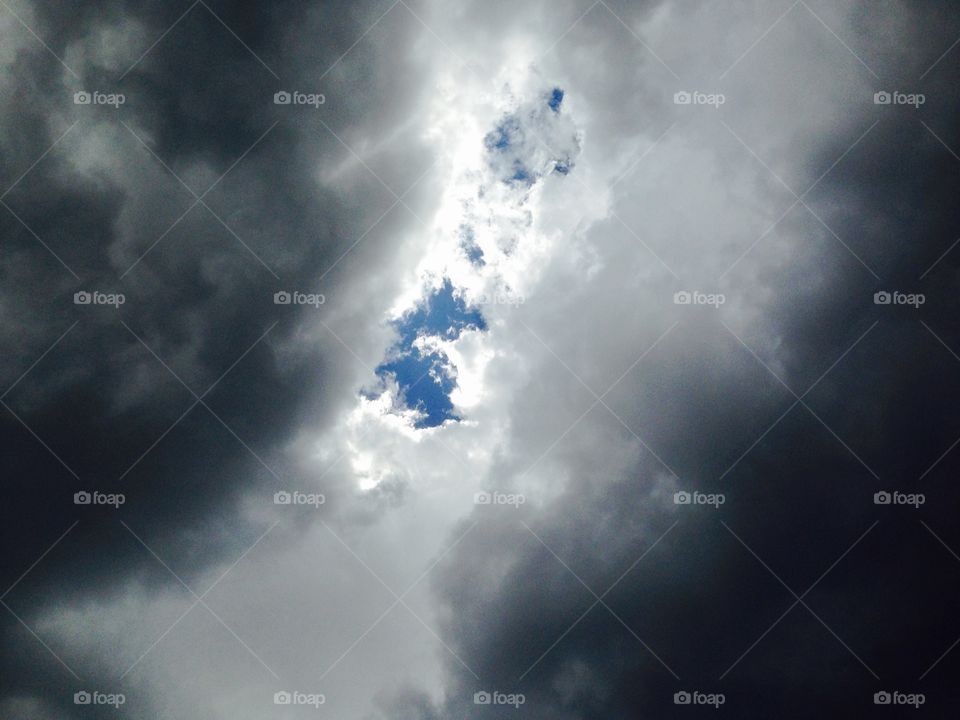 Parting of the Storm. Storm clouds break apart to reveal a blue sky and sunshine