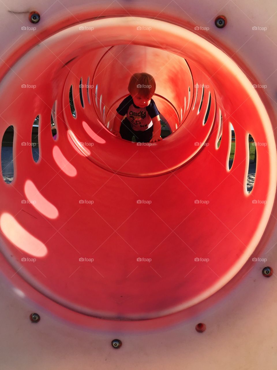 Baby crawling inside the red tunnel