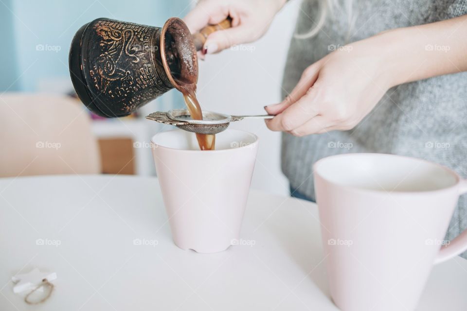Women pouring tea in cup