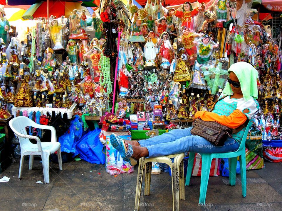 asian street vendor selling religious figurines outside if quiapo church in manila, philippines in asia