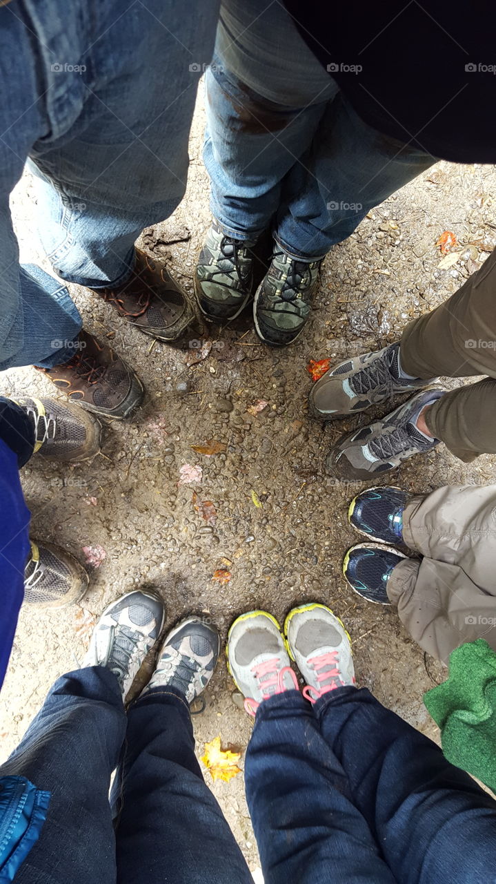 Group photo of everyone's muddy feet after a mountain hike in the rain.