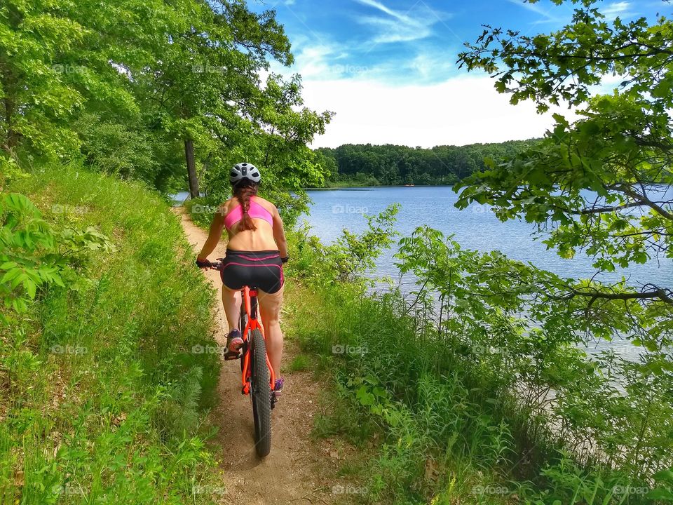 pony tail cyclist by Lake