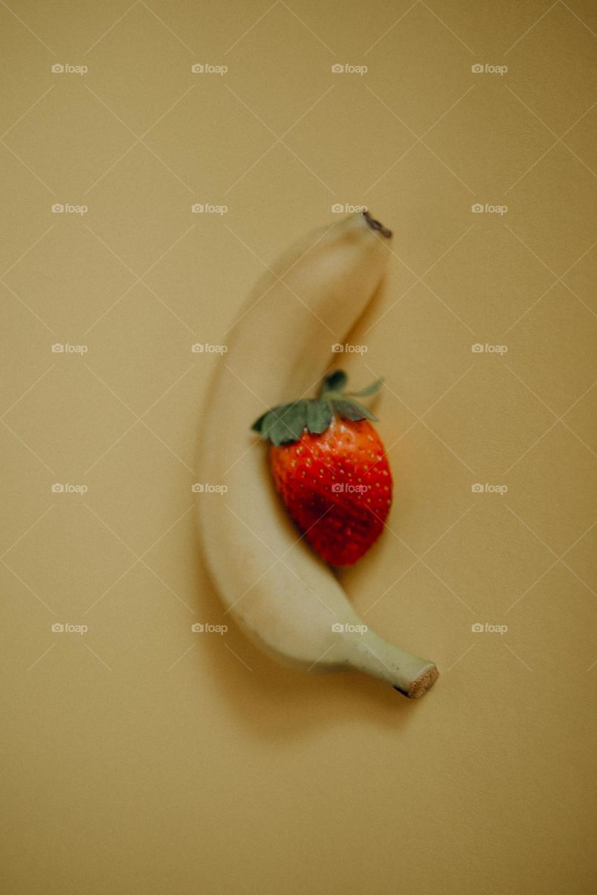 Banana and Strawberry on Yellow Background