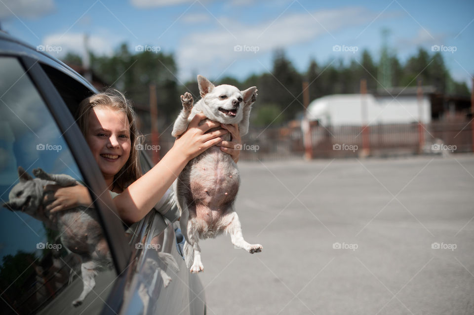 Happy girl and dog in car