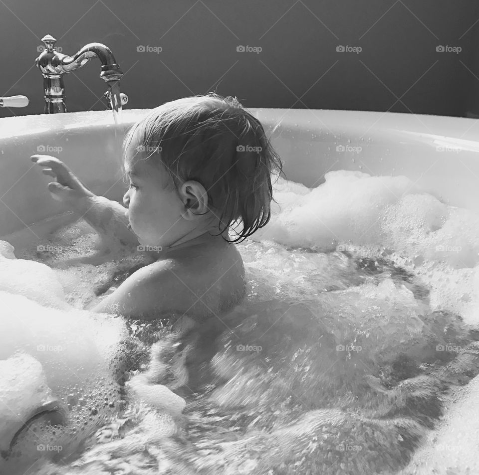 Cute baby bathing in bathtub