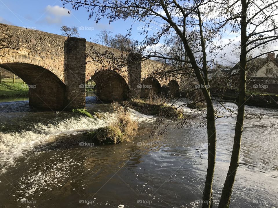 A beautiful country bridge combined with an impressive waterfall.