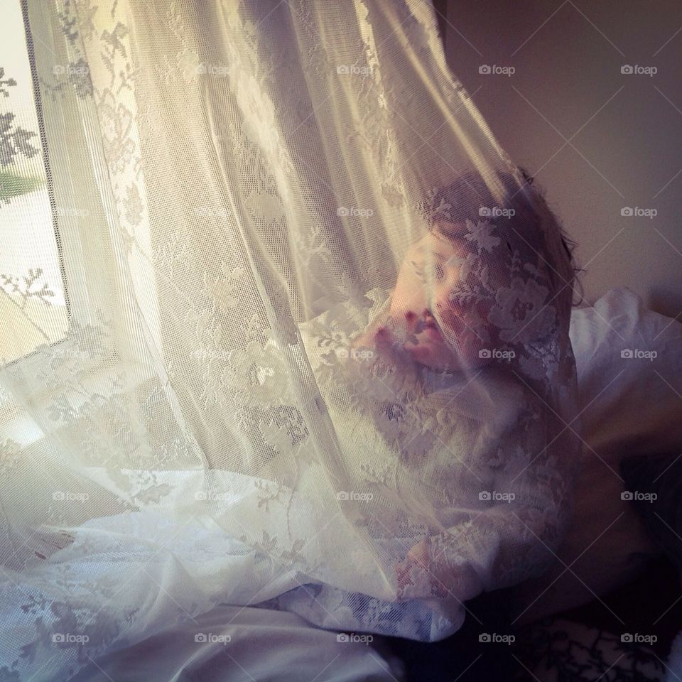 Baby behind lace curtain 