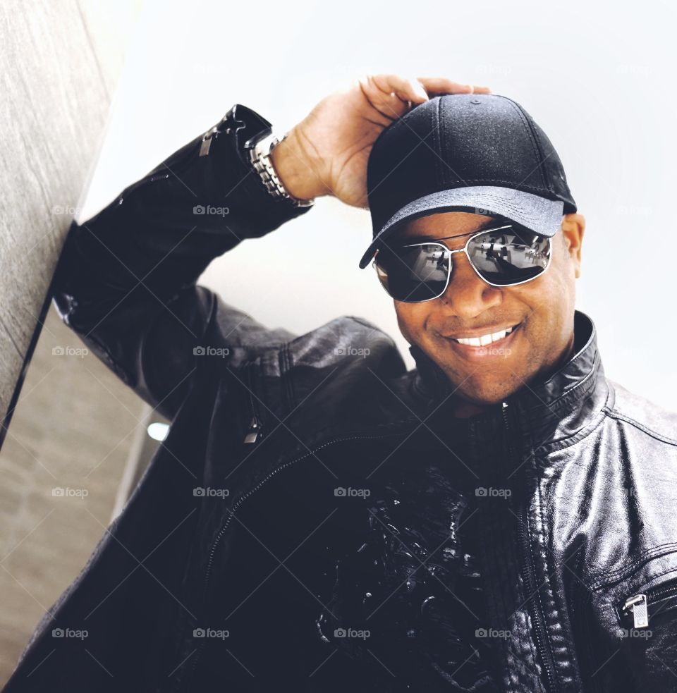 Portrait of a happy african man wearing cap and sunglasses