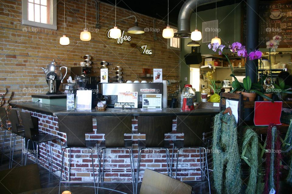 Counter front view hanging lights cement countertop bricks open ceiling warm colors 