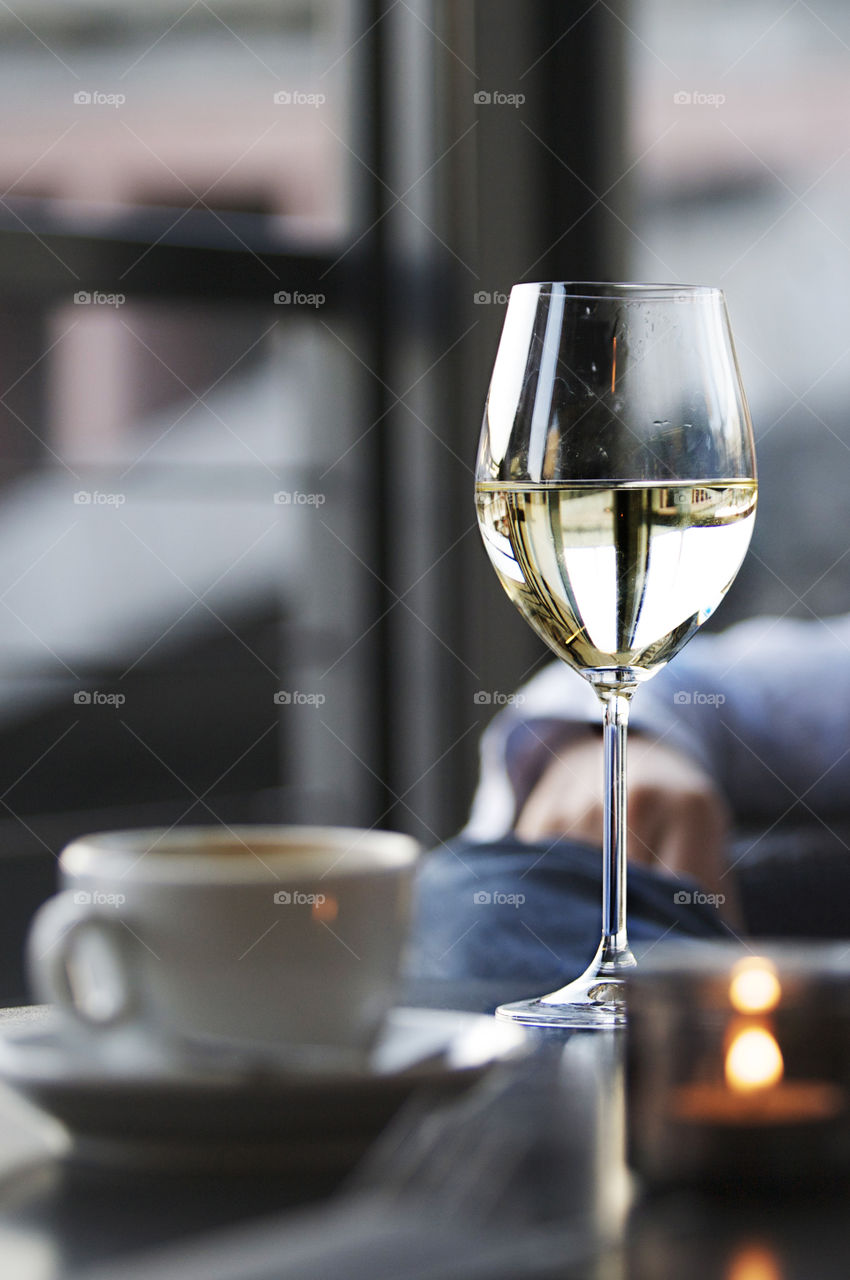 Relax. Wine glass and cup of coffee on table at a cafe