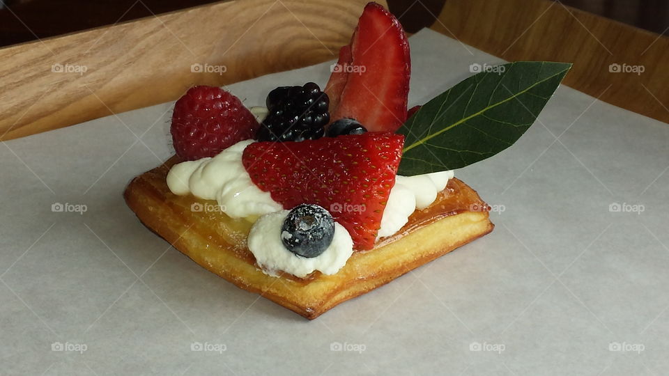 Wild berry in cream on a flaky pastry