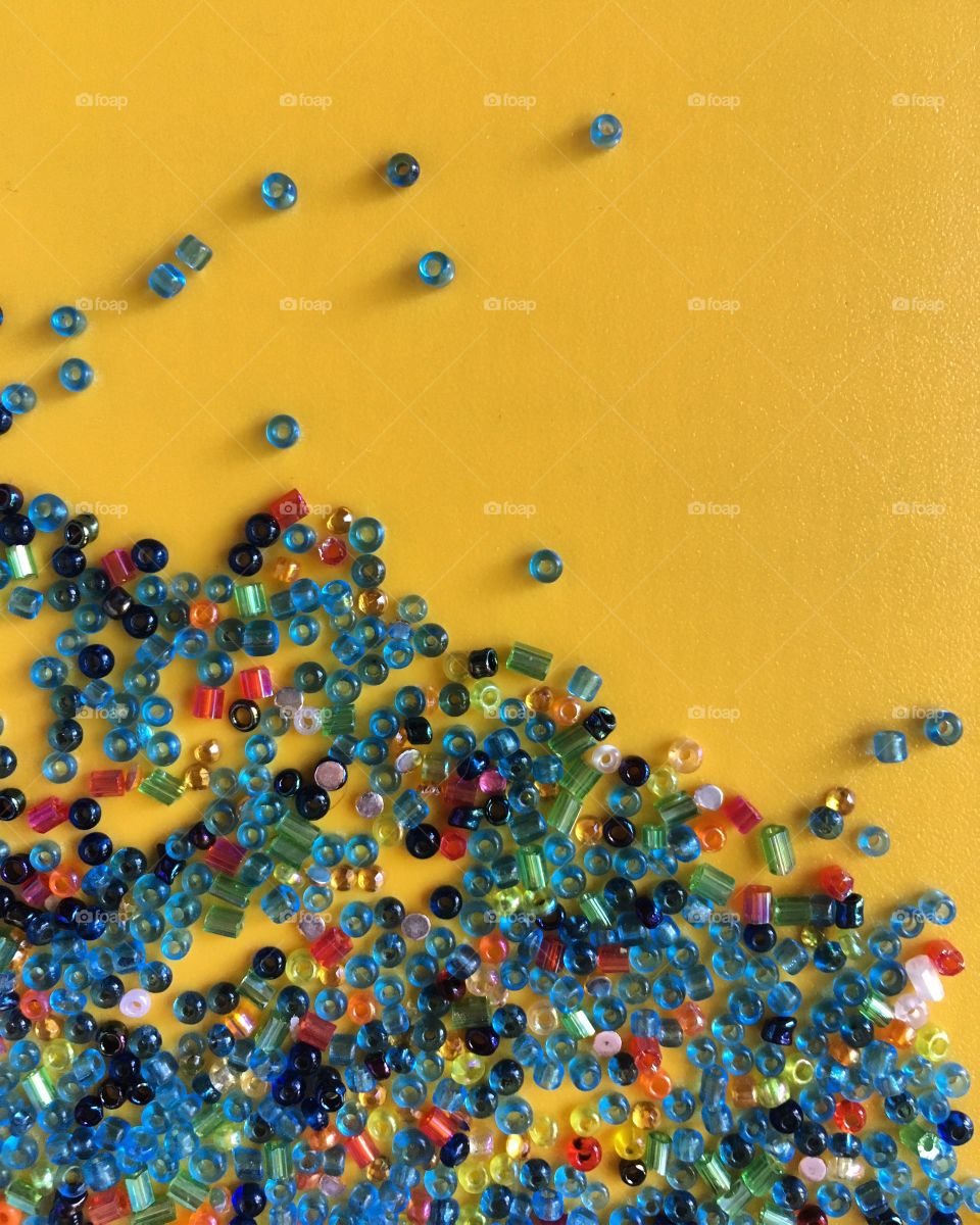 Multicolored beads on a yellow background