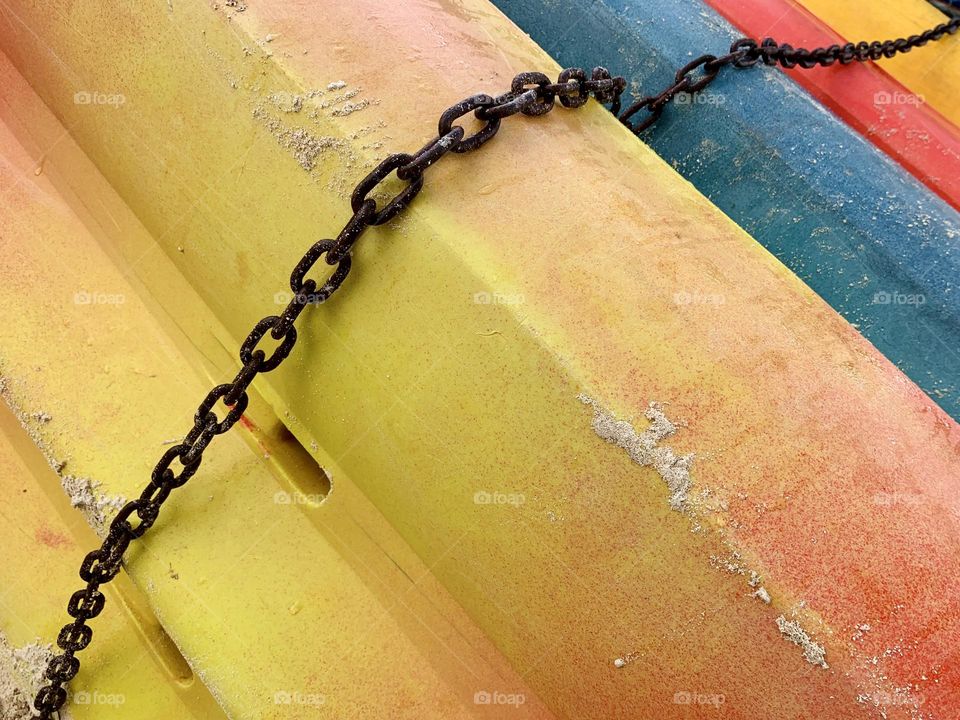 Different colors of chained kayak boat on the shore in a close up photos. Bahamas. 