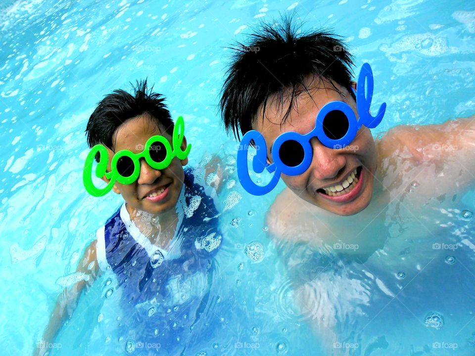 young boys in a swimming pool with funny sunglasses