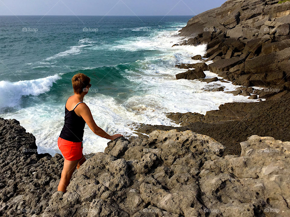 A woman looking at the coastline at Cantabria, Spain