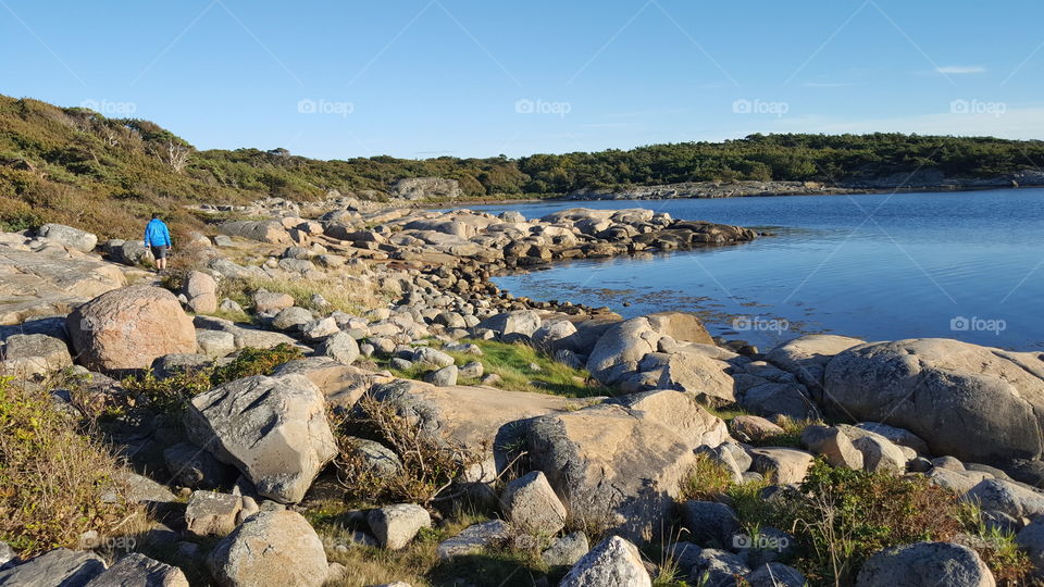 Rear view of a man walking near the coast