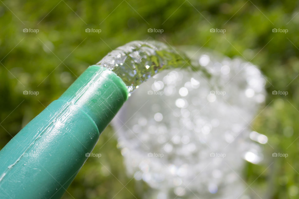 Pouring water from a green watering can 