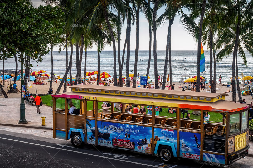 Waikiki trolley shuttle bus parked along Kalakaua Avenue, Waikiki Beach area, Honolulu, Hawaii. This is a cheap form of transportation and is hugely popular among tourists.