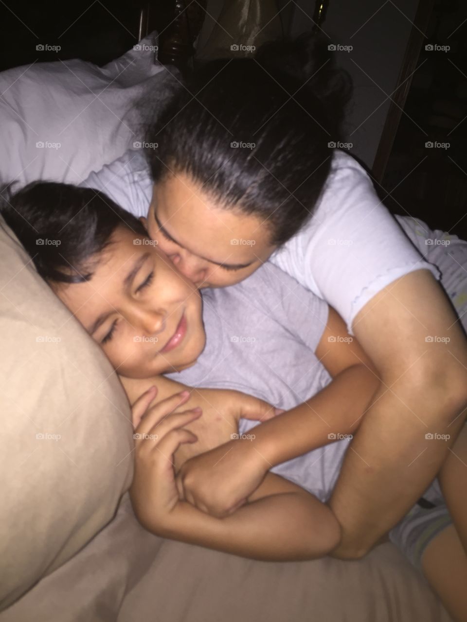 Mom kissing son good night