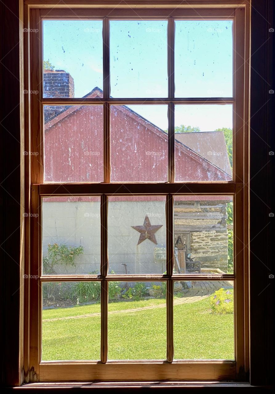 Looking out through a window towards an old house with a star