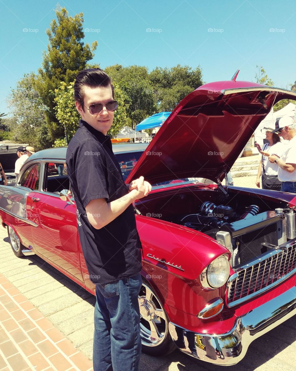Retro Rockabilly Man with Greaser Hair at Car Show Looking at Hotrod Cars
