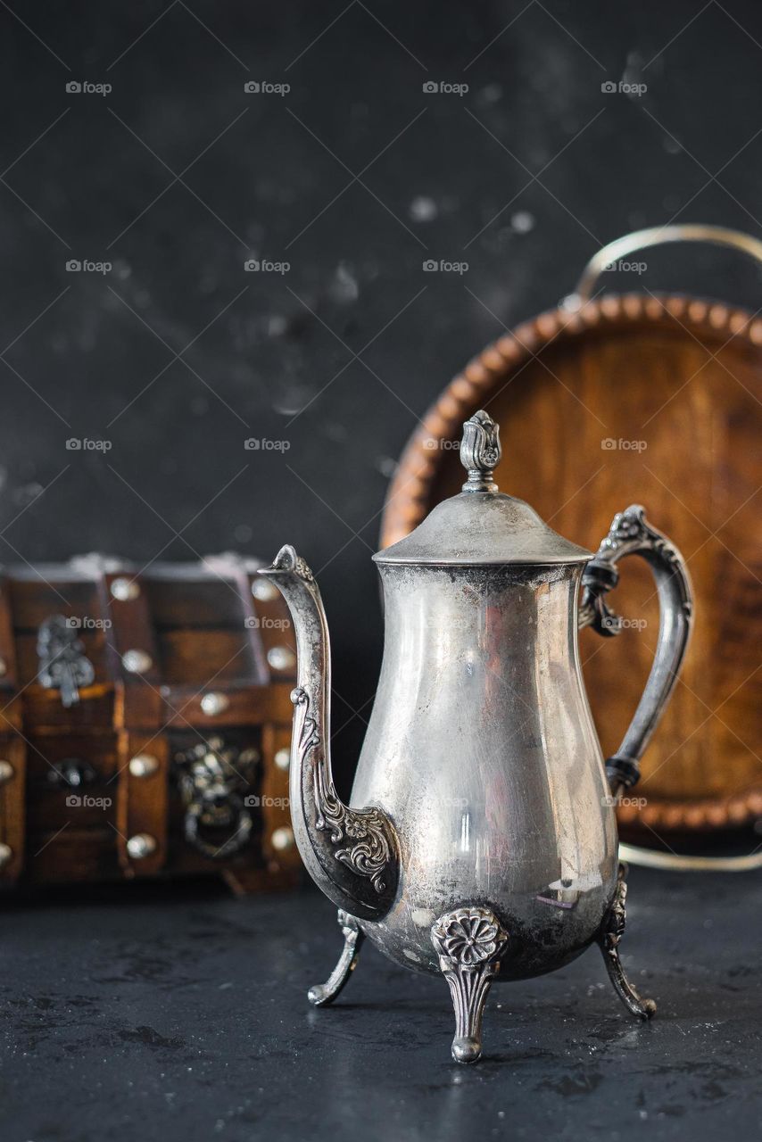 Antique metal jug with wooden box and wooden tray.