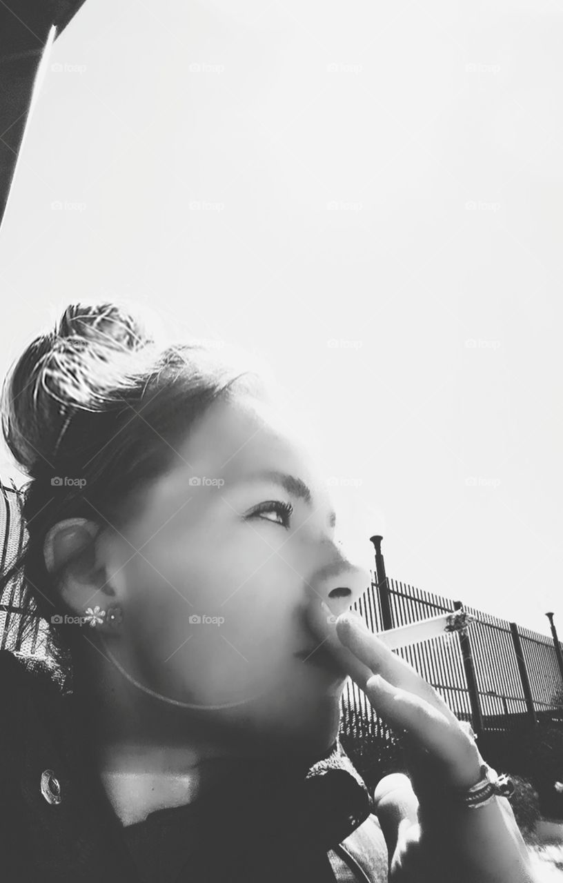 black and white side profile of woman smoking a cigarette