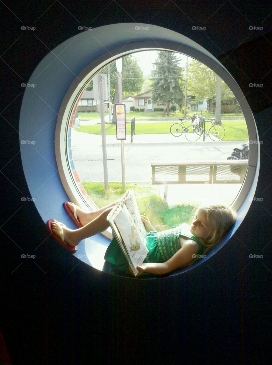 girl reading in library window