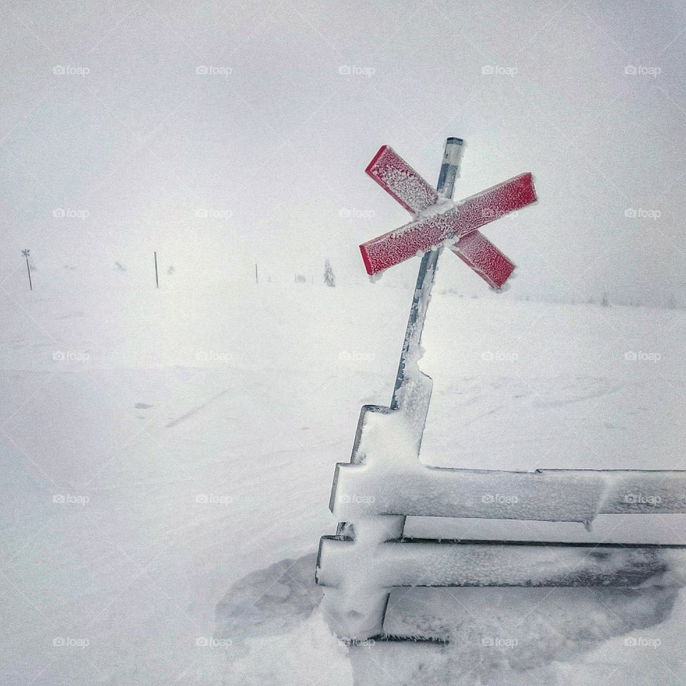 Wood cross in snow storm. Red wood cross in snow storm on the mountain