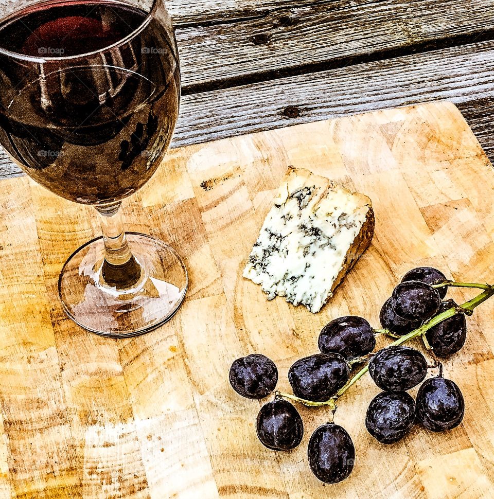 Grapes and blue cheese with drink on wooden table