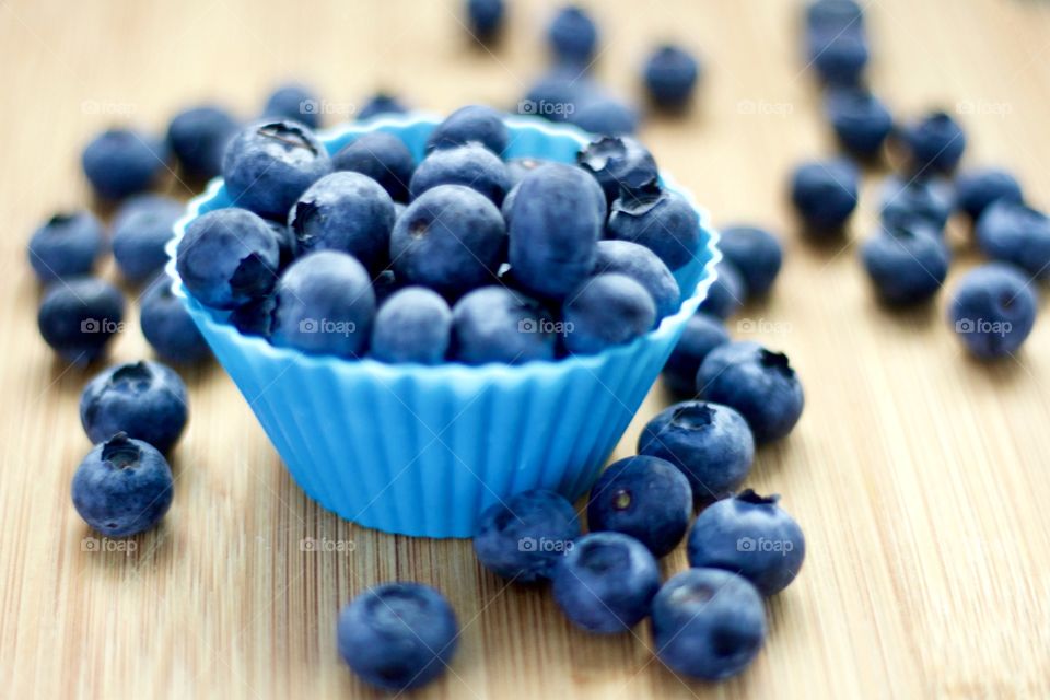 Fruits! - Blueberries In blue silicone baking cups on bamboo surface
