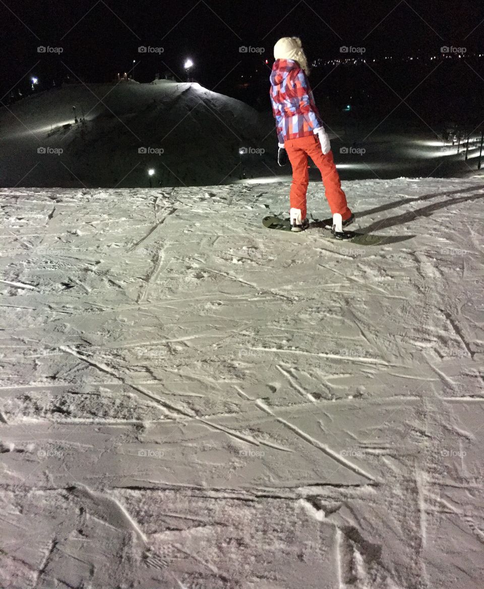 Skateboarder in snow during night