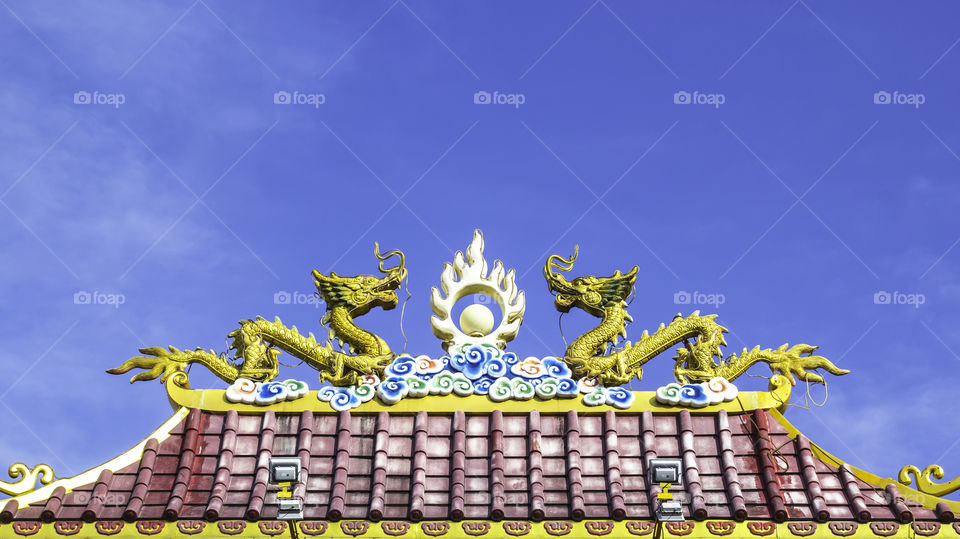 Two dragon statue on Chinese roof with the sky background