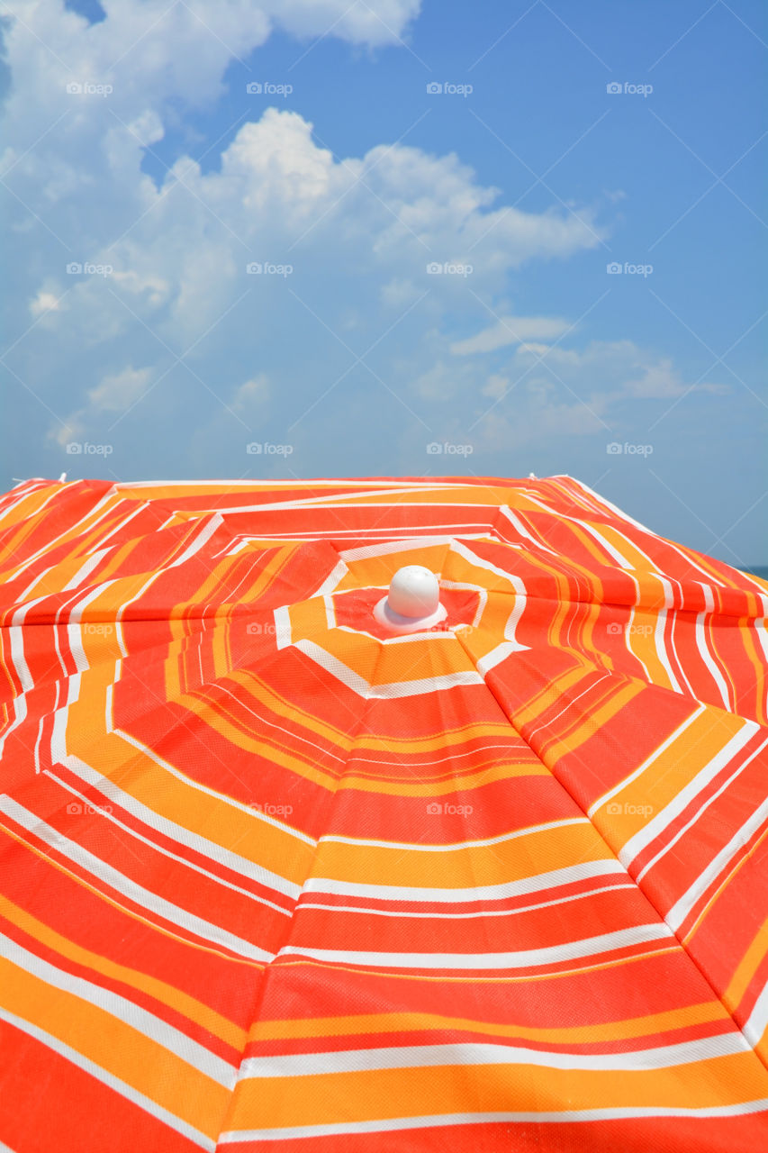 Pretty striped orange beach umbrella.