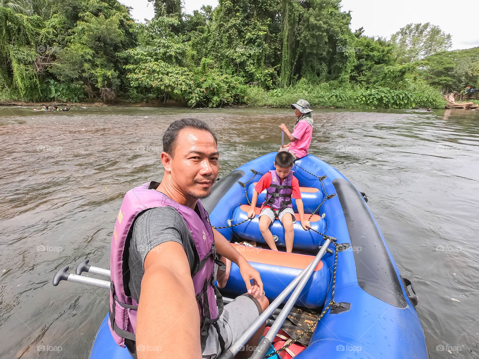 Tourists on the inflatable boat floating on the water in the river The flow of Kaeng Krachan Dam at Phetchaburi in Thailand. June 10, 2019